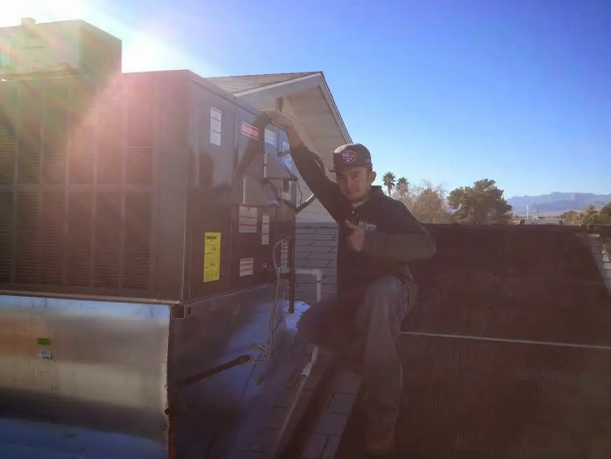 HVAC technician performing HVAC Inspection on a rooftop unit in Midland